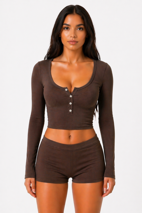 Woman wearing a taupe brown long-sleeve top and shorts on a white background
