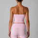 Woman wearing a pink strapless top and shorts set on a gray background