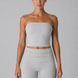 Woman wearing a gray strapless top and shorts set on a gray background