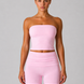 Woman wearing a pink strapless top and shorts on a gray background