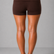 Brown shorts worn by a person on a gray background