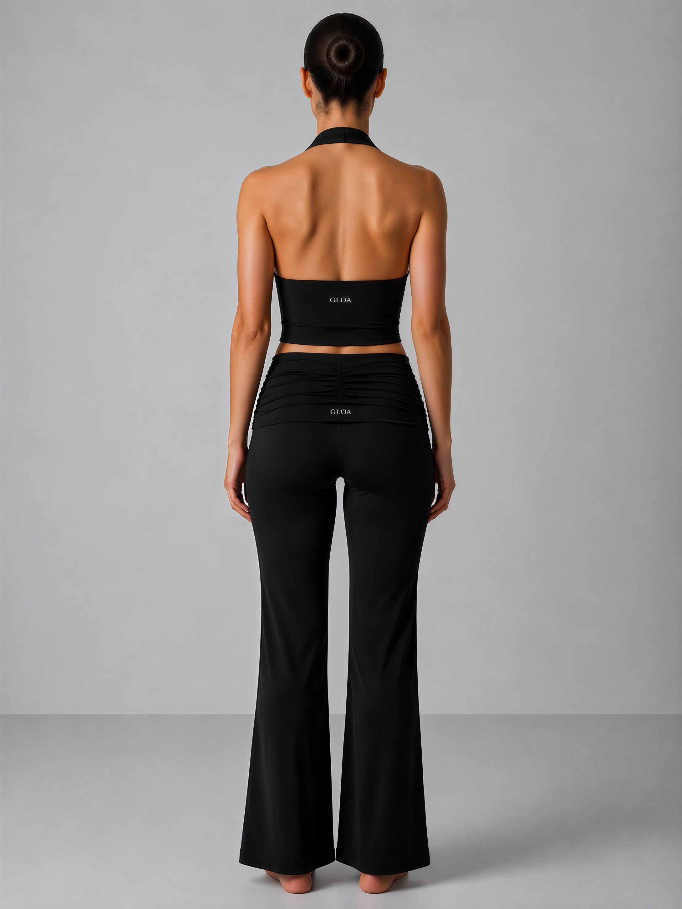 Person wearing a black outfit with 'Gloa' branding on a gray background