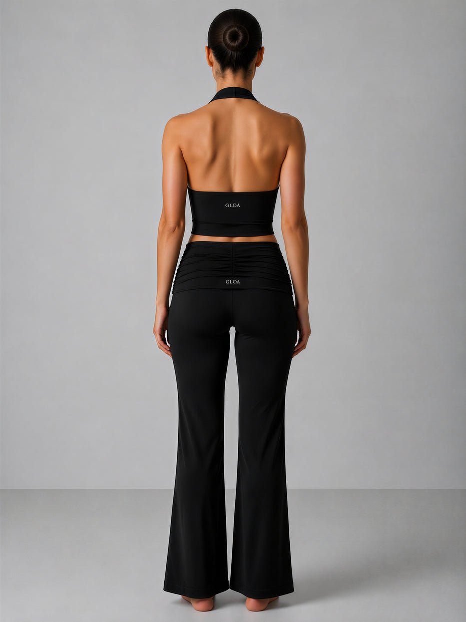 Person wearing a black outfit with 'Gloa' branding on a gray background