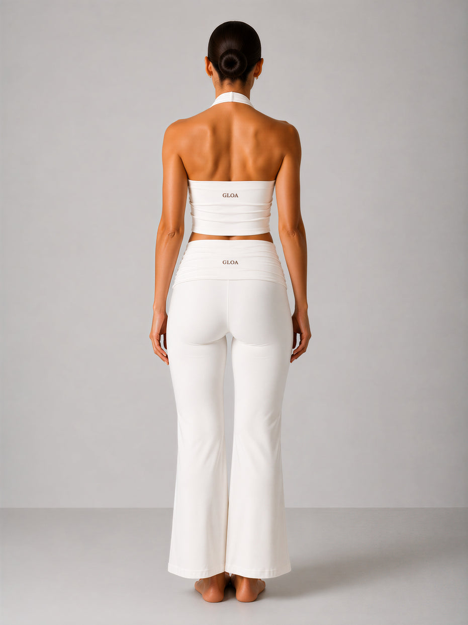 Woman wearing a white outfit with 'Gloa' branding on a plain background