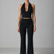 Woman wearing a black halter top and black pants on a gray background