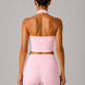 Person wearing a pink halter and leggings set on a gray background