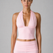 Woman wearing a pink halterand leggings on a gray background