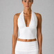 Woman wearing a white halter top and pants on a gray background