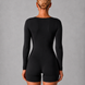 Person wearing a black bodysuit against a gray background