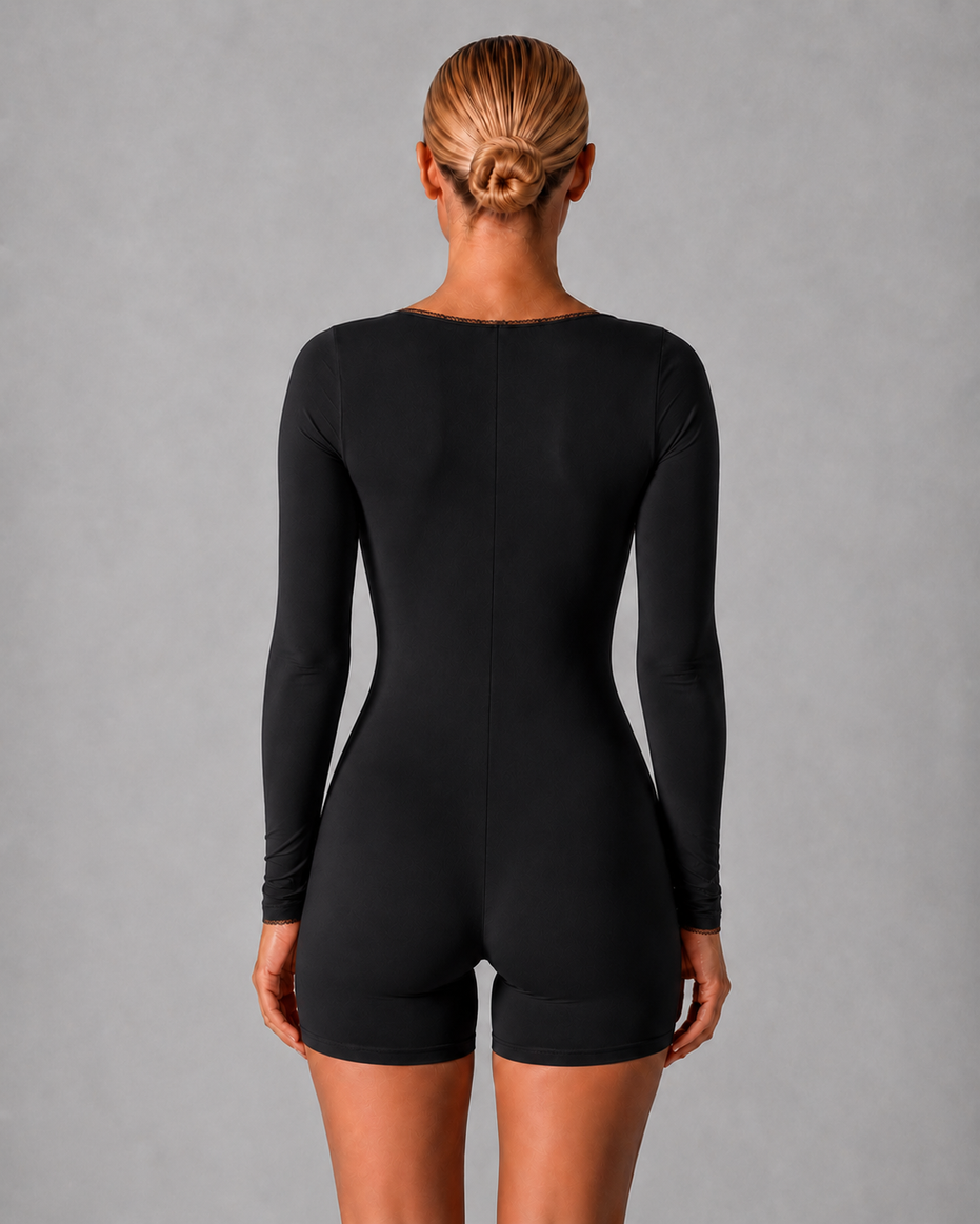 Person wearing a black bodysuit against a gray background