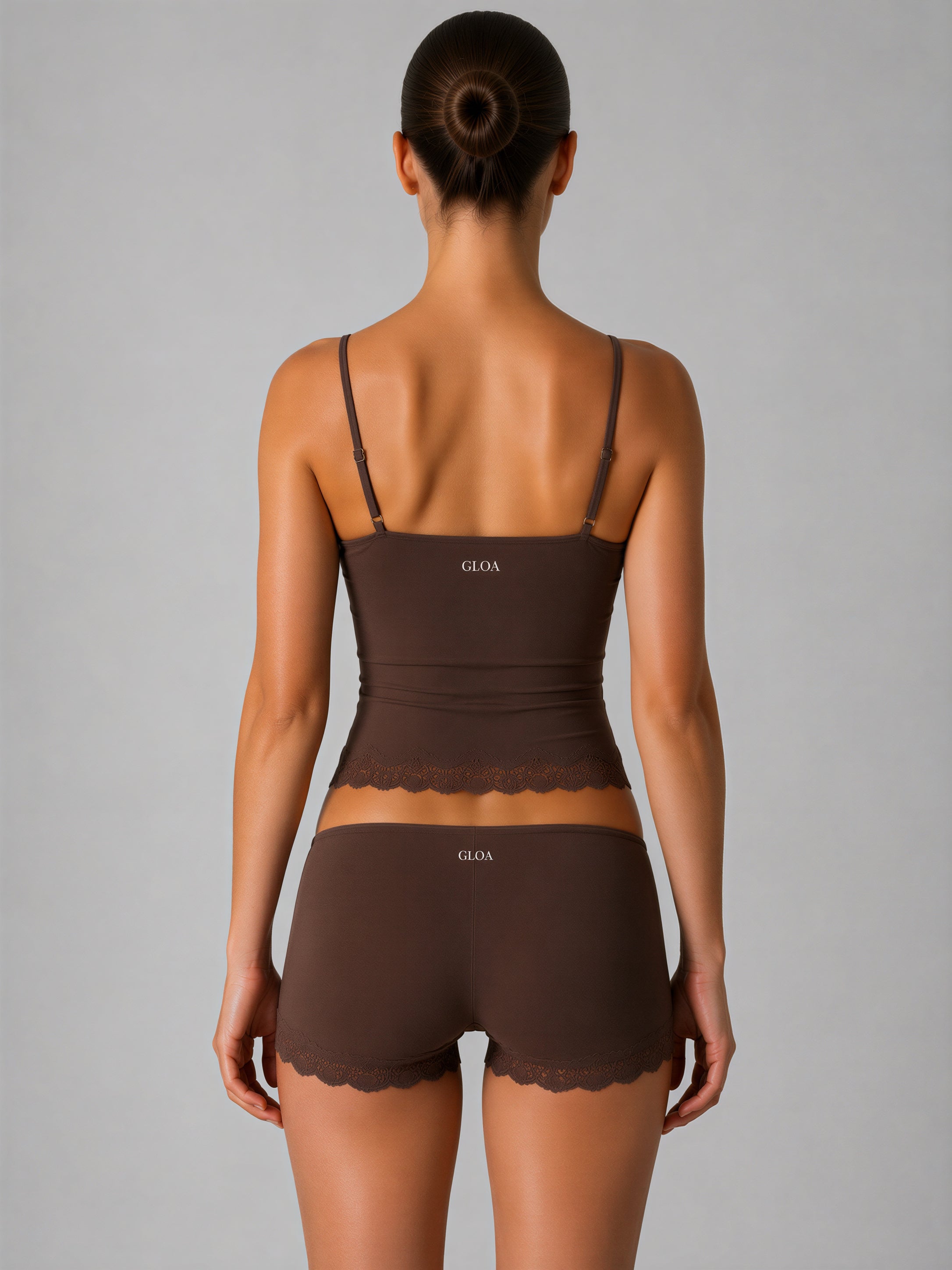 Woman wearing a brown lingerie set with 'Gloa' branding on a gray background