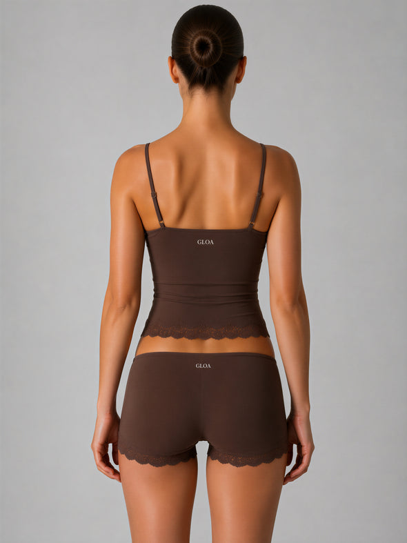 Woman wearing a brown lingerie set with 'Gloa' branding on a gray background