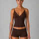 Woman wearing a brown lace lingerie set against a gray background
