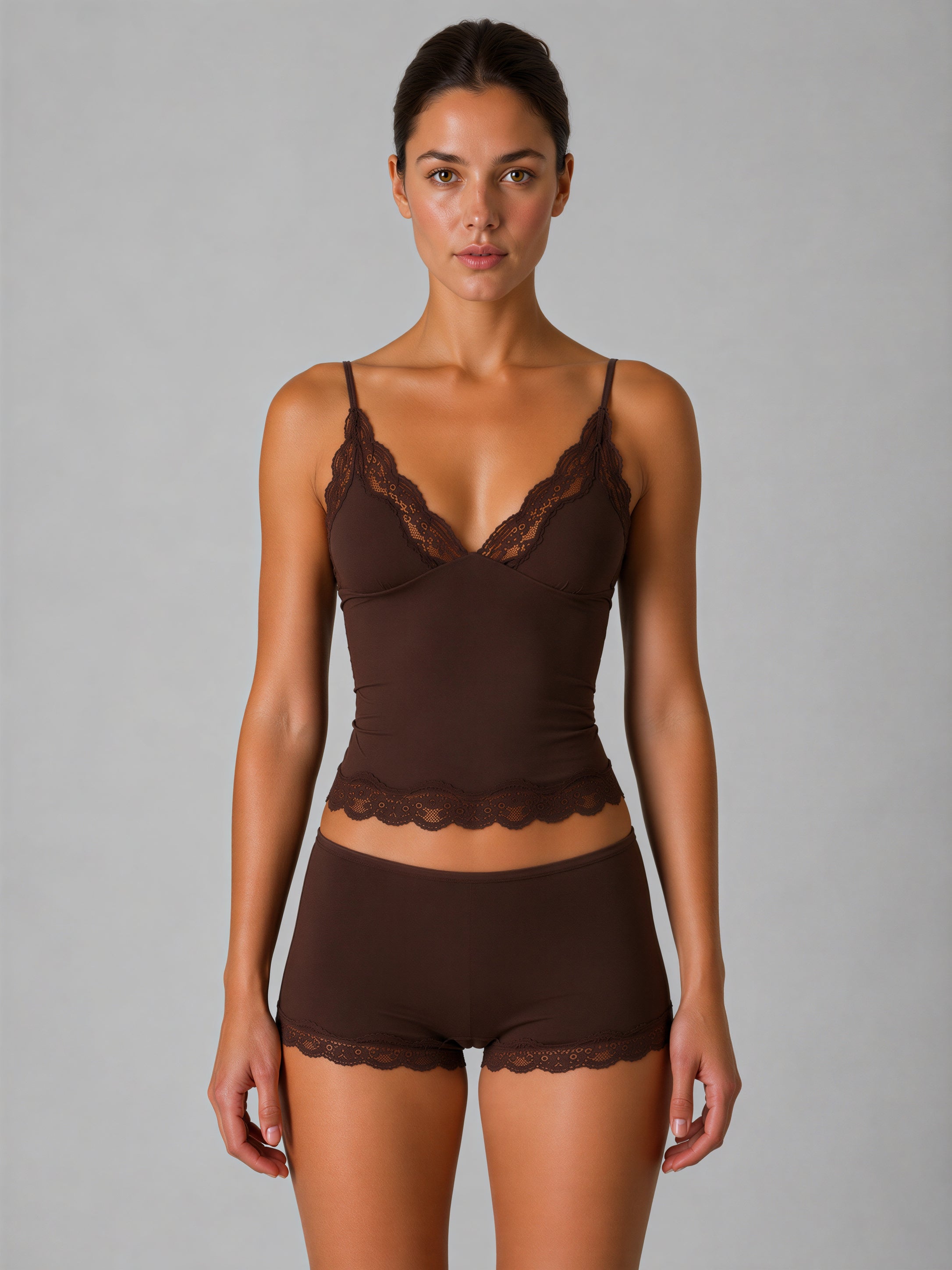 Woman wearing a brown lace lingerie set against a gray background