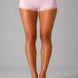 Person wearing light pink lace-trimmed shorts on a gray background
