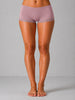Person wearing purple lace-trimmed shorts on a gray background