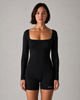 Woman wearing a black bodysuit with 'GLOA' branding on a gray background